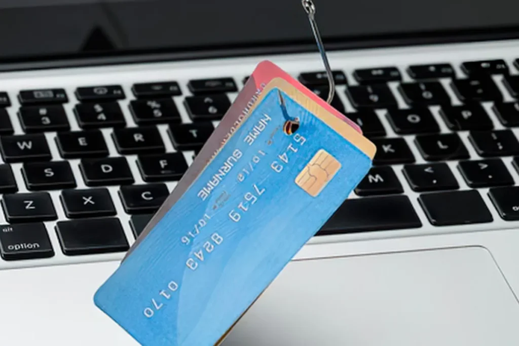 Computer keyboard in background with credit cards on a hook. Concept.
