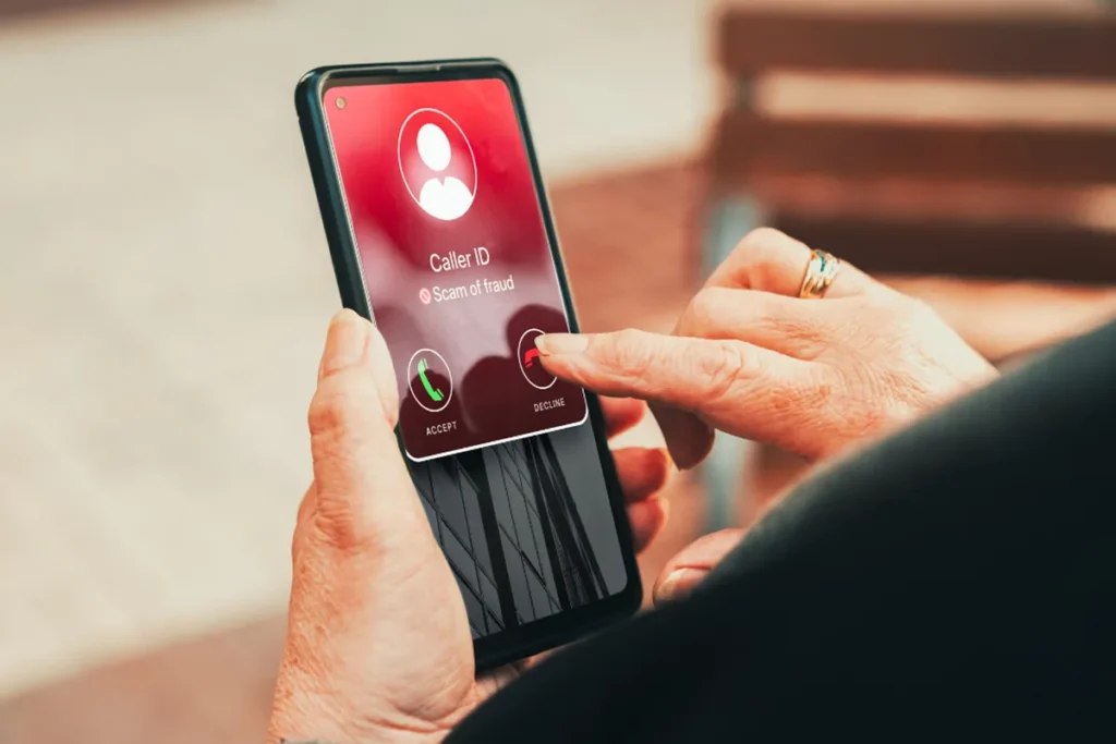 Cell phone with screen saying scam or fraud.